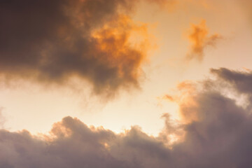 evening sky in orange glow. huge fluffy clouds. dramatic natural background in summer