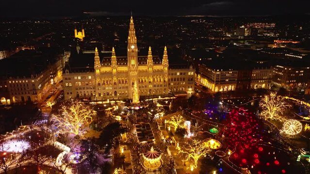 Beautiful colorful aerial shot of park in front of City hall. Color light decoration at markets and illuminated historic building. Vienna, Austria