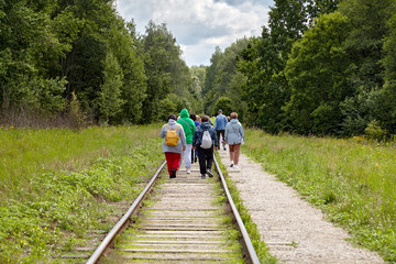 A group of migrant refugees moves along abandoned railway tracks in the forest