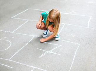 Kid playing hopscotch on playground outdoors