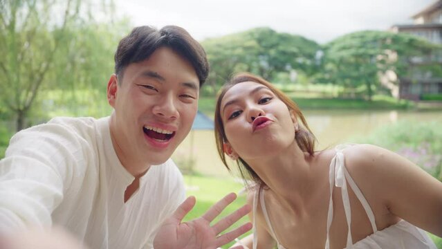 Asia people young adult man woman relax smile looking at camera take photo social media vlog video at outdoor hotel enjoy fun date day. Joy happy asian lovers wife husband just married sweet newlywed.