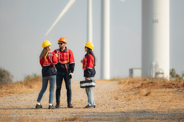 Team of engineers working on wind turbines in a wind farm