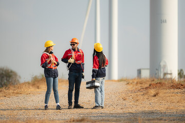Team of engineers working on wind turbines in a wind farm