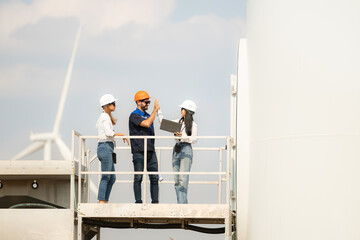 A group of engineers and architects work in floor of base ground of a wind turbine