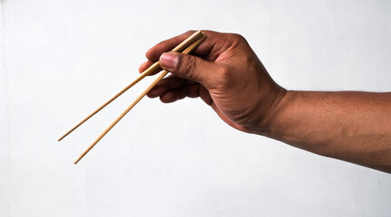 man's hand holding chopsticks isolated white background