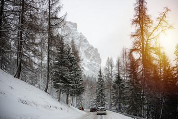 Winter road among forest in Dolomite mountains, Italy