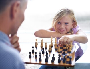 Smile, child and father play chess in home, family bonding together or development. Happy girl, man...