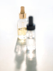 Serum with collagen and peptides in colorful glass bottles on light background