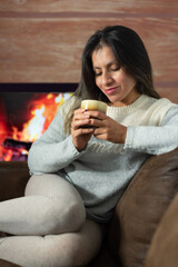 Woman enjoys a drink while relaxing at home.