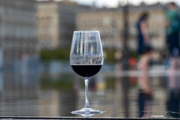 Tasting of Bordeaux blended red wine with wine city Bordeaux on background, left bank of Gironde...