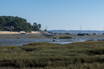 View on Arcachon Bay at low tide with many fisherman's boats and oysters farms, Cap Ferret peninsula, France, southwest of Bordeaux along France's Atlantic coastline