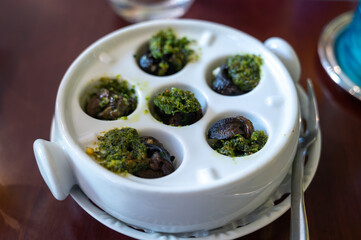 Starter dish in traditional restaurants on Burgundy, snails cooked with butter, garlic and herbs, France