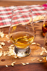 Tasting of different Scotch whiskies strong alcoholic drinks, drum of whiskey and colorful Scotch tartan on background close up
