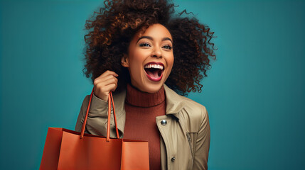 Excited young african american woman holding a bag in the hand isolated on sea blue background, positive emotion, sale discount shopping concept, person with a bag, having fun shopping - obrazy, fototapety, plakaty