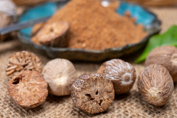 Tasty winter spice whole dried and ground powder nutmeg, used as an ingredient in many dishes, eggnog, potato, mulled wine