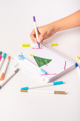 Naklejka premium School supplies, teenager's hand drawing with markers, white background, selective focus.