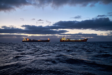 Cargo operations between Fpso tanker and shuttle tanker in the sea, with dramatic sky.