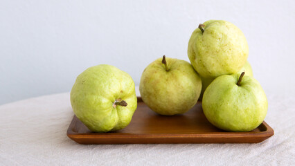 guavas on a wooden tray on the table