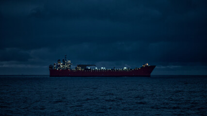 Silhouette of oil tanker in the sea at night. © Igor Hotinsky