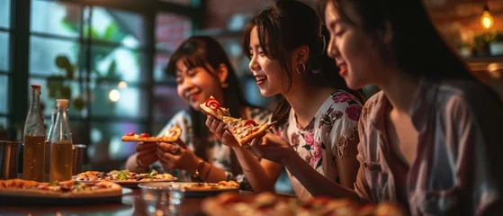 Tuinposter Happy Asian Three young female friends eating pizza party at home © Onchira