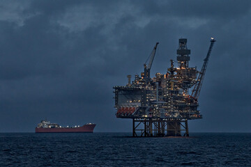 Crude oil production in the sea with jackup drilling rig and floating production storage tanker at...