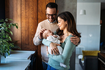 Portrait of parents and newborn baby. Father and mother kiss and hug a beautiful newborn child. .