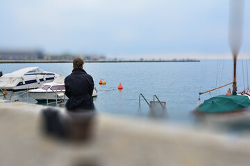 Person looking at the sea sitting at the port - 713227917