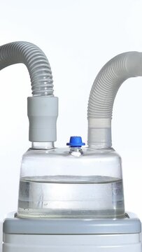 connecting the cepap respirator tubing to the air humidifier. vertical photo with white background