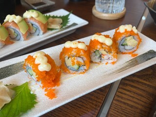 sushi salmon roll  , sashimi salmon are in plate on wooden table in Japanese restaurant during dinner with family on New Year party celebration day