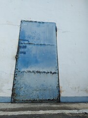 Rusty blue iron door commonly used in old textile factories