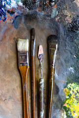 old brushes and palette knife on a palette with paints