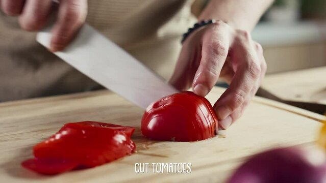 Hands of chef slicing ripe tomato with knife on wooden cutting board, subtitles displaying below screen. Video recipe for social media channel or cooking blogHands of chef slicing ripe tomato with kni