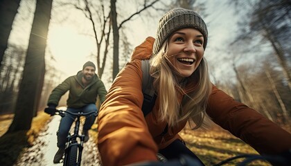 Obraz premium Close up of two mountain bikers on the way at sunset in sport clothing. Young couple athlete cyclist in outdoor nature healthy active lifestyles.