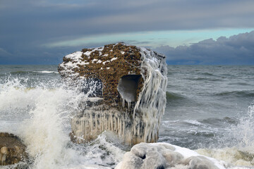 Ruins of military fortifications in winter on the Baltic Sea coast near Liepāja, Latvia.