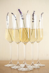 Glasses of champagne decorated with lavender on blurred background