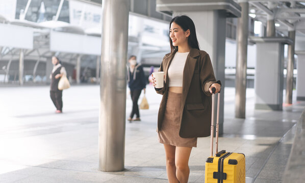 Freelance young asian woman walking with travel luggage for business trip