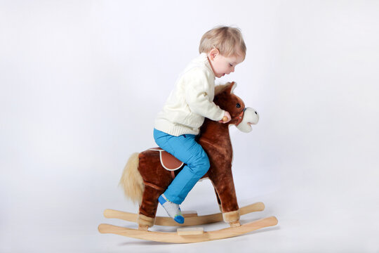 boy on a wooden horse. child rocking horse little boy riding a toy horse, rocking chair children's toy vintage