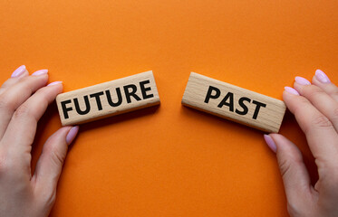 Future or Past symbol. Concept word Future or Past on wooden blocks. Businessman hand. Beautiful orange background. Business and Future or Past concept. Copy space