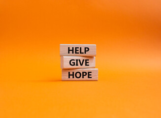 Help Give Hope symbol. Concept words Help Give Hope on wooden blocks. Beautiful orange background. Business and Help Give Hope concept. Copy space.