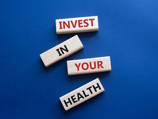 Invest in your Health symbol. Concept words Invest in your Health on wooden blocks. Beautiful deep blue background. Business and Invest in your Health concept. Copy space.