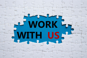 Work with us symbol. Concept words Work with us on white puzzle. Beautiful blue background. Business and Work with us concept. Copy space.