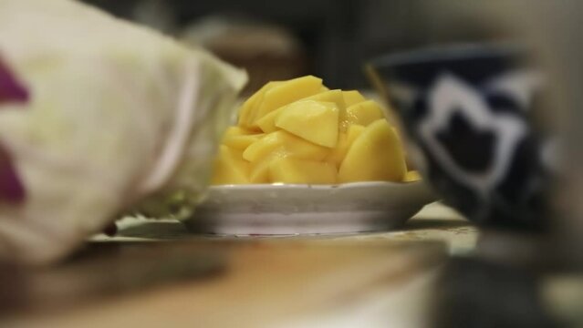 Woman's hands preparing cabbage for slicing on a cutting board.