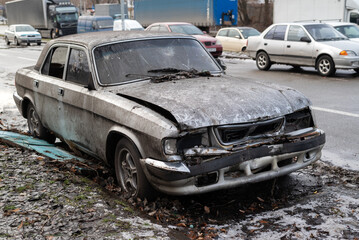 old abandoned rusty car smashed by looters on the street of a city in Ukraine