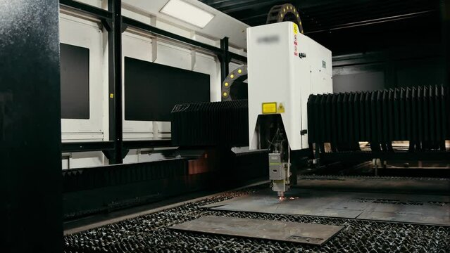 Plasma cutting of metal with a cnc. A plasma cutter cuts a workpiece from a sheet of metal. Laser cutter in production. Industrial metal cutting by plasma laser. 
