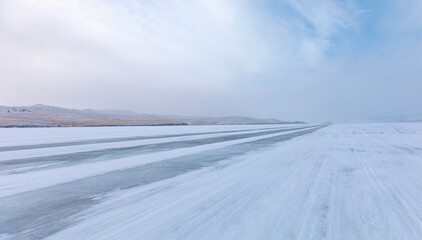 Beautiful winter landscape with car tire tracks (trail) in fresh snow - Baikal Lake, Siberia