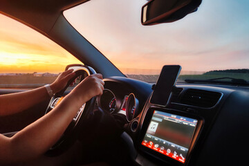 Driving a car at amazing sunset.