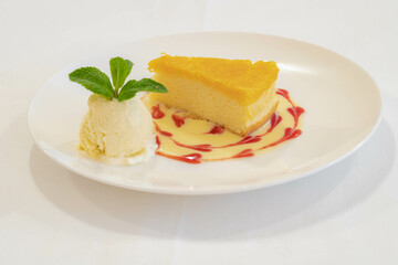 Sweet and dessert concept, Selective focus of homemade golden  Chiffon cake with egg yolk threads (Cake Foi-Thong) served with custard and vanilla ice cream decorate with mint in white plate.