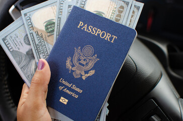 Fototapeta premium Inside a car, a hand holds a closed American passport, revealing the anticipation of new destinations.