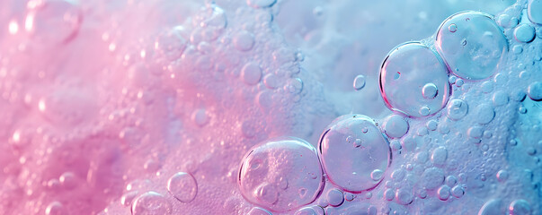 Background with foam made of soap, shampoo, lotion, detergent in blue and pink colour. Macro photo of bubbles in water. Banner for laundry and cleaning services, spa, beauty and skin care concept.