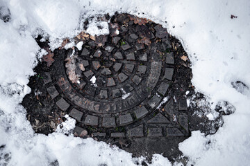 sewer cover under snow